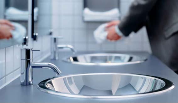 Row of commercial washroom basins and taps