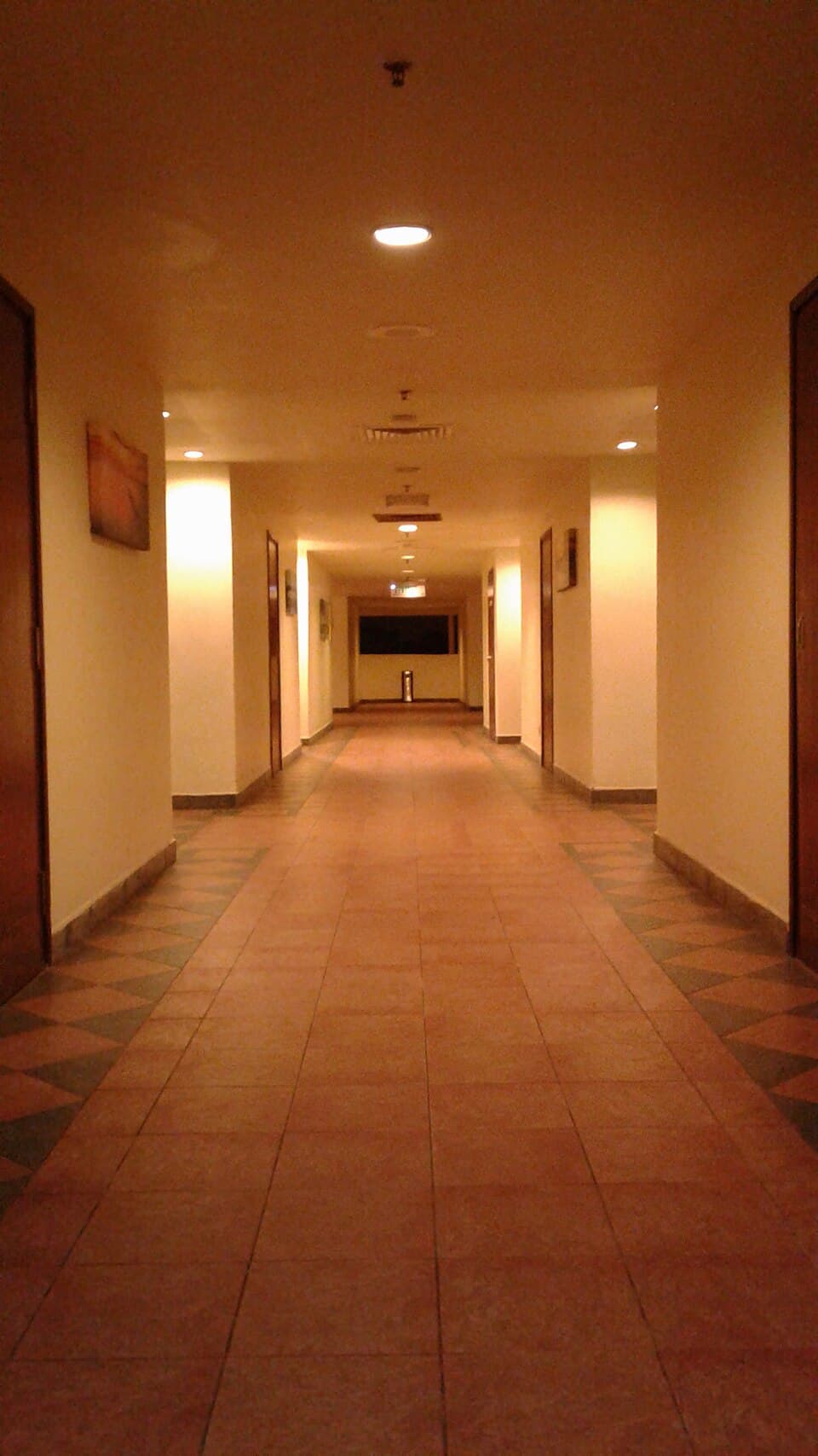 Long hotel corridor with room doors